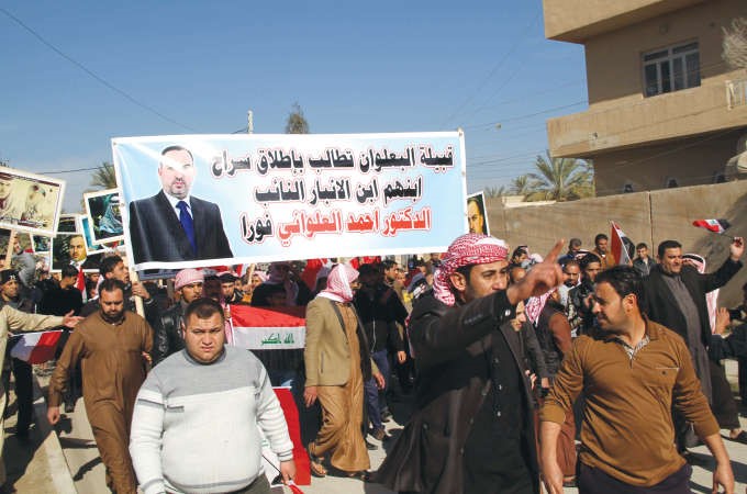 متظاهرون عراقيون يحملون لافتات تطالب باطلاق سراح النائب احمد العلواني الذي فجر اعتقاله احداث الرمادي افپ