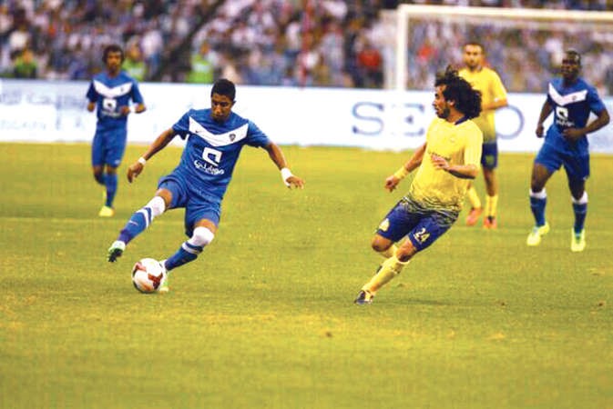 لاعب الهلال سالم الدوسري يحاول المرور من مدافع النصر حسين عبدالغني