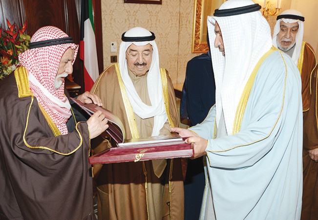 صاحب السمو الامير الشيخ صباح الاحمد يتسلم كتابا من دعبدالله المعتوق وحمود الرومي ويبدو دخالد المذكور