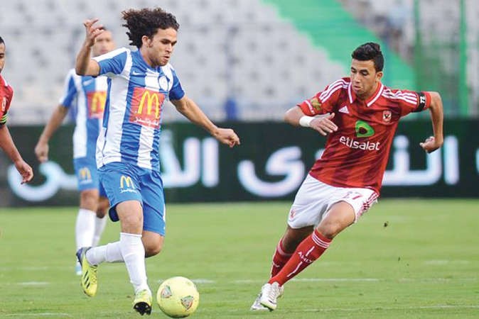 لاعب الاهلي محمود حسن تريزيغيه يحاول انتزاع الكرة من مدافع الداخلية