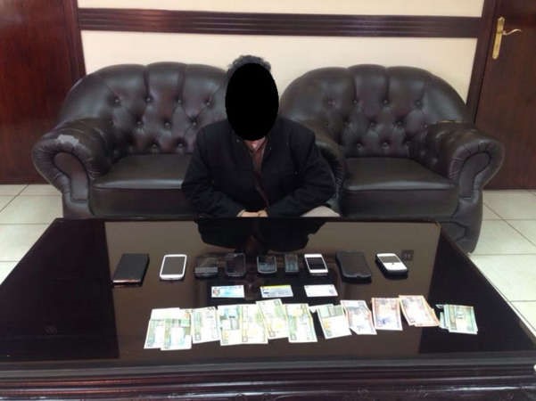 احد اللصين وامامه كمية من الهواتف المسروقة﻿