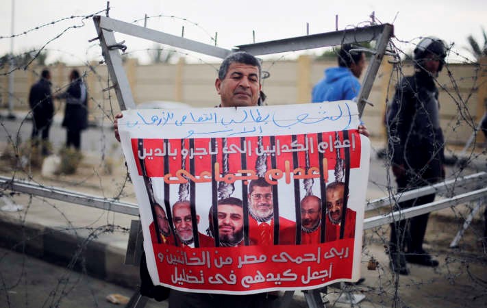 مصري معارض لحكم الاخوان يحمل لافتة تطالب باعدام قادة الجماعة اثناء محاكمة محمد مرسي امسرويترز