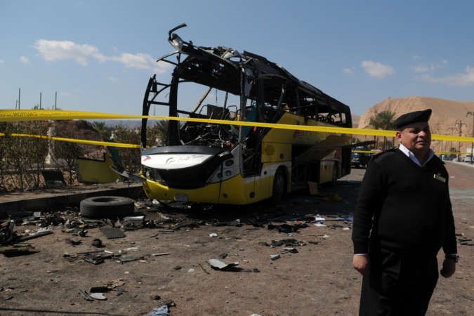 شرطي مصري يقف بجوارحافلة السياح المحطمة التي استهدفتفي طابا امس الاولافپ