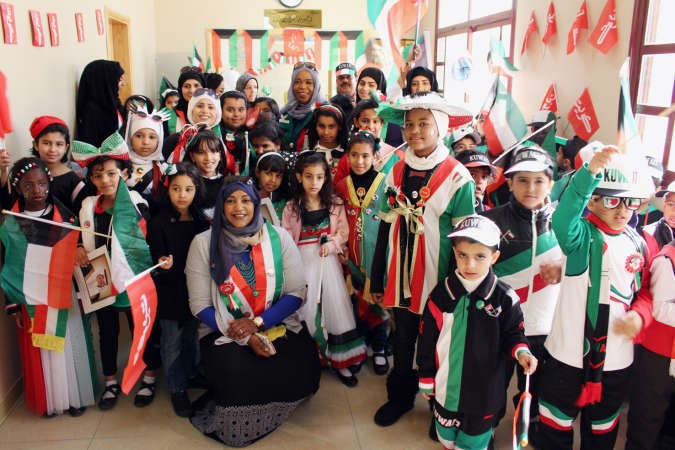 عدد من العاملين والطلبة والطالبات يتشحون باعلام الكويت﻿