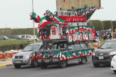 صور صاحب السمو الامير الشيخ صباح الاحمد وسمو ولي العهد الشيخ نواف الاحمد والاميرين الراحلين الشيخ جابر الاحمد والشيخ سعد العبدالله - رحمهما الله - مع اعلام الكويت تزين احدى السيارات المشاركة في مسيرة الاحتفالات هاني عبدالله