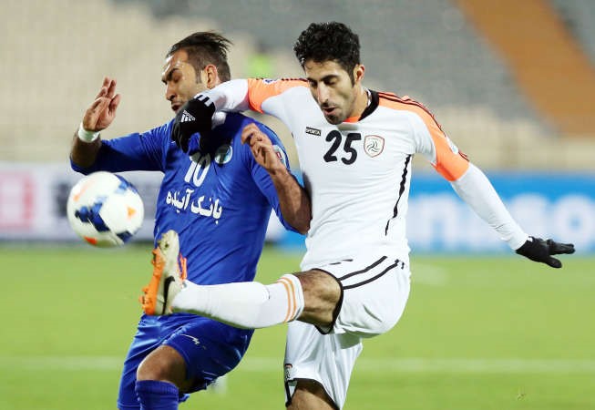 مدافع الشباب ماجد المرشدي يبعد الكرة من امام مهاجم الاستقلال سيافاش اكبربور افپ