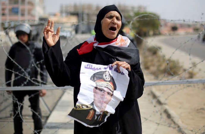 مصرية مؤيدة لترشيح المشير السيسي للانتخابات الرئاسية ترفع صورة له امام مقر محاكمة الرئيس المعزول محمد مرسي امس رويترز