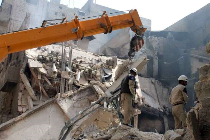 رجال طوارئ يزيلون اثار الدمار بحثا عن احياء نتيجة القصف على حي بستان القصر في حلب امس افپ

