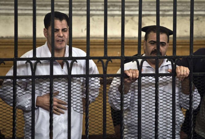 الشرطيان عوض سليمانيمين ومحمود صلاحيسار في قفص الاتهاماثناء جلسة النطق بسجنهما 10 سنوات امسافپ 