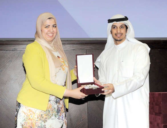 عبدالرحمن المطيري يتسلم درعا تكريمية من دفاطمة الموسوي ﻿