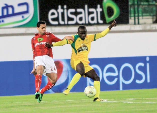 لاعب الاهلي احمد فتحي يحاول انتزاع الكرة من مدافع يانغ افريكانز