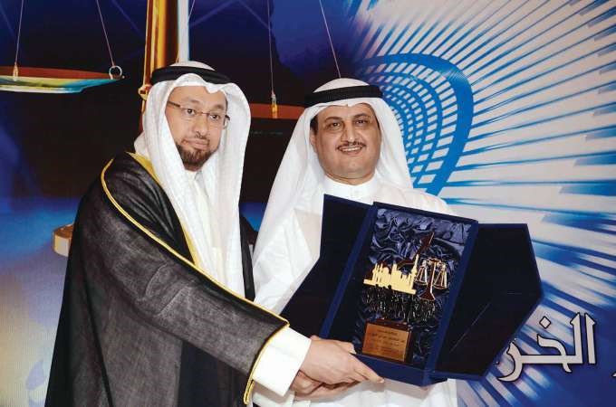 لؤي الخرافي يسلم دمنصور السعيد الدرع التكريمية الخاصة بوزير التجارة لرعايته الحدث