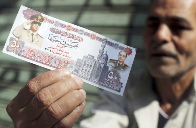 بائع مصري بميدان التحرير يرفععملة ورقية طبعت عليها صورة المشير السيسيامس رويترز