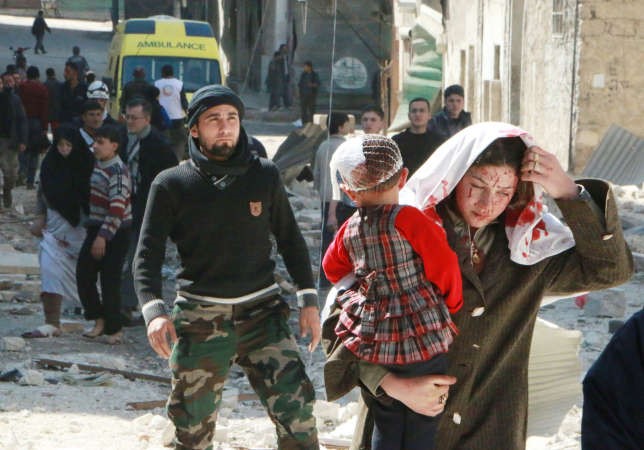 سيدة مصابة تحمل طفلتها بعد غارة جوية على احد احياء حلب امس افب
