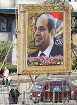 مصريون يمرون بالقرب من صورة لدعم المشير السيسي للانتخابات الرئاسيةاپ﻿