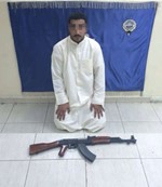  المتهم وامامه السلاح المستخدم 