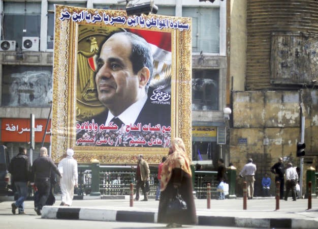 مصريون يمرون بالقرب من صورة كبيرة تدعم ترشح المشير السيسي للرئاسة في القاهرة امس رويترز