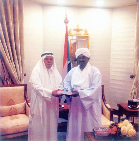 الرئيس السوداني المشير عمر البشير يتسلم كتابا من الزميل منصور الهاجري 