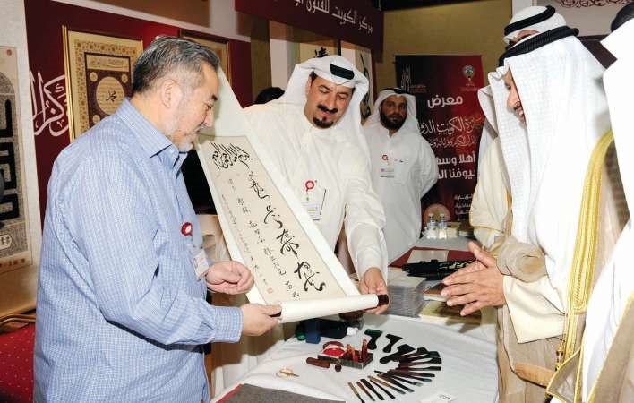 سمو رئيس الوزراء الشيخ جابر المبارك يستمع لشرح من فريد العلي حول احدى المخطوطات ﻿