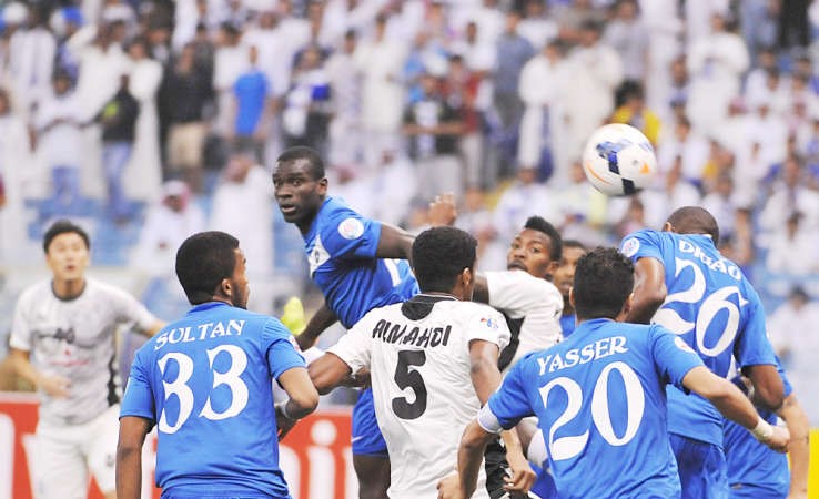 محترف الهلال ديغاو يبعد الكرة براسه وسط مجموعة من اللاعبين افب