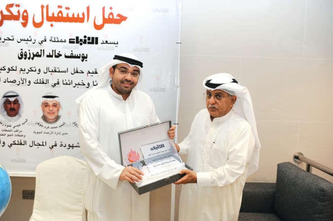 الفلكي عادل يوسف المرزوق يتسلم تكريمه من رئيس التحرير الزميل يوسف خالد المرزوق
