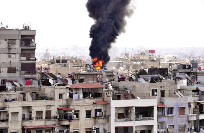 صورة وزعتها سانا لما قالت انها السنة لهب ودخان من موقع سقوط قذيفة هاون في حي الاطفائية بدمشق امس الاول	افپ﻿