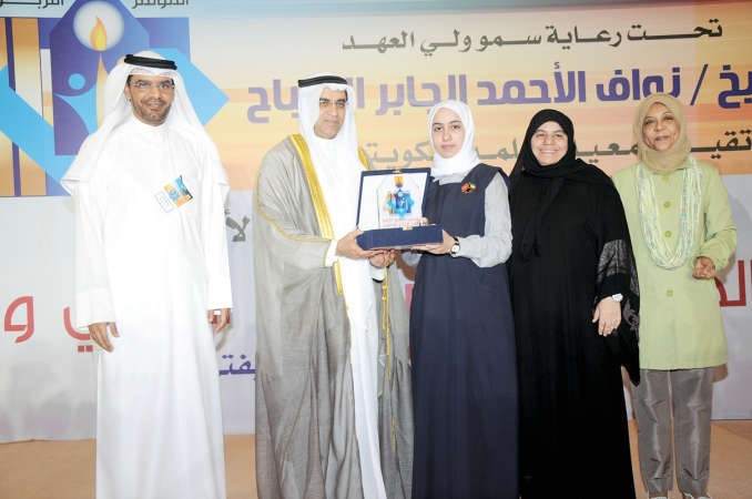 احمد المليفي ومتعب العتيبي ومريم الوتيد خلال تكريم احدى الطالبات المتميزات