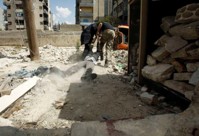 ثوار يسحبون جثة زميل لهم قتل في مواجهات مع قوات النظامفي حي العامرية بحلب امس رويترز 