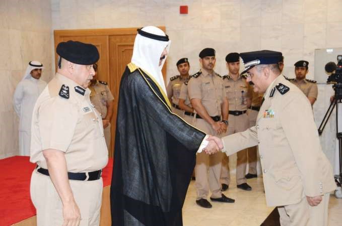 الشيخ محمد الخالد يصافح اللواء محمد العنزي بعد تقليده رتبته الجديدة ويبدو الفريق الفهد﻿