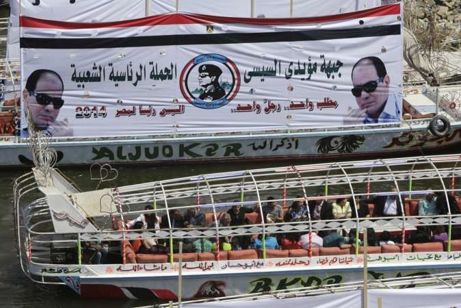 مصريون يستقلون مركبا يحمل لافتات تدعم المشير السيسي خلال جولة في نهر النيل بالقاهرة امس اپ 