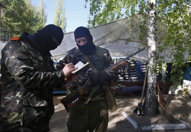 مسلحون موالون لروسيا خلال تمركزهم في احد المواقع بسلوفنسك شرق اوكرانيا امس 	اپ ﻿