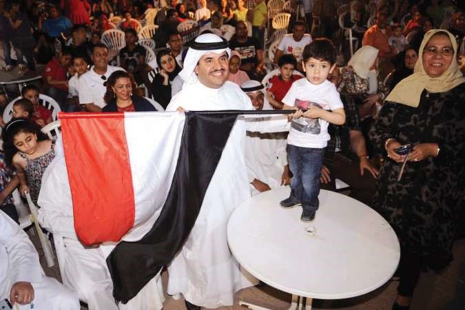 الشيخ دعيج الخليفة وعبدالله ابن الزميلين محمود فاروق والاء خليفة يرفعان علم مصر﻿