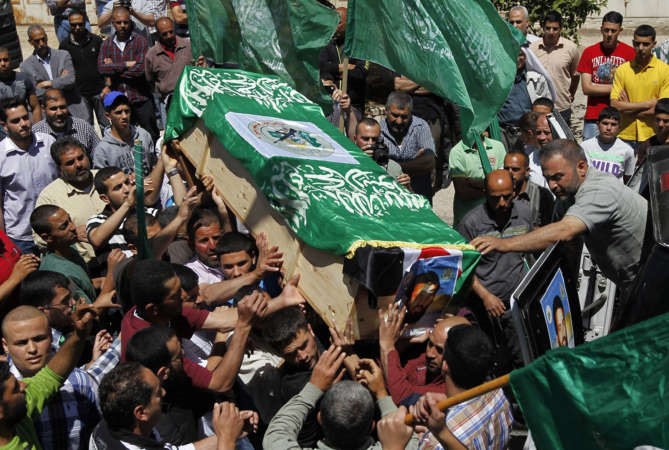  فلسطينيون يشيعون رفات عنصرين من حماس قضيا عام1998 خلال مراسم برام الله امس الاول 	افپ﻿