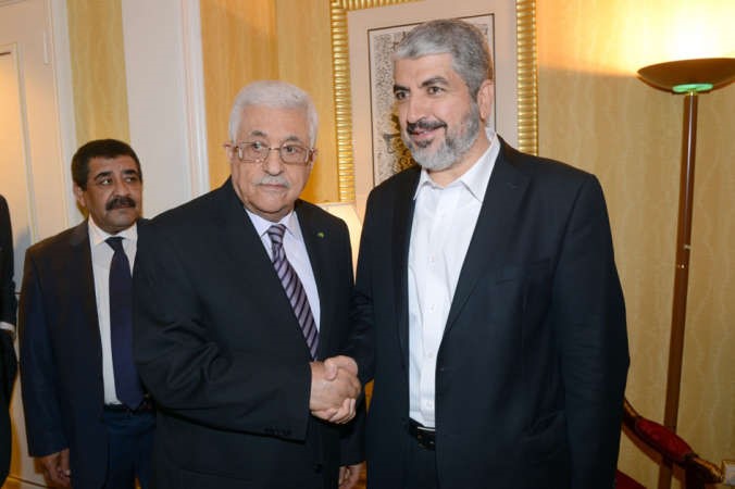 الرئيس الفلسطيني محمود عباسمصافحارئيس المكتب السياسي لحركة حماس خالد مشعل خلال لقائهما بالدوحة امس افب