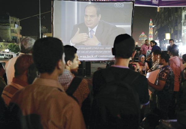 انصار المرشح الرئاسي المشير عبد الفتاح السيسي يتابعون لقاءه التلفزيوني عبر شاشة عملاقة في احد شوارع القاهرةافپ