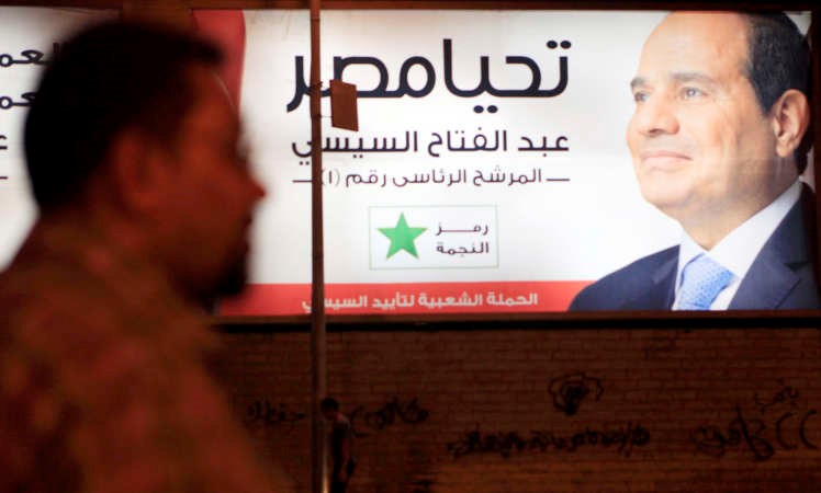 مصري يمر امام لوحة تدعم ترشح المشير عبد الفتاح السيسي للرئاسة في القاهرة امس	 رويترز﻿