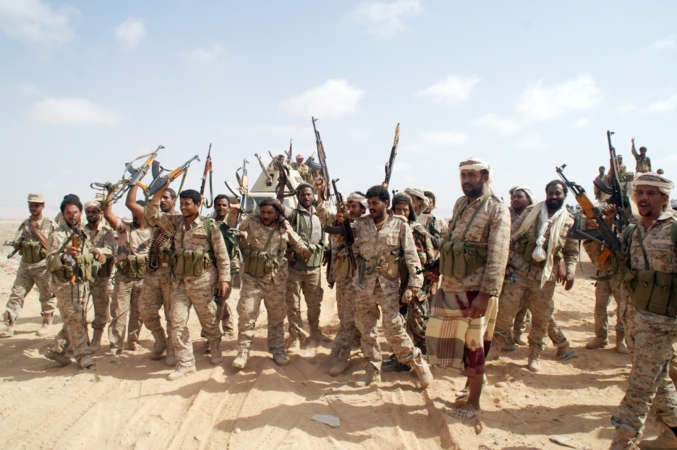 جنود يمنيون يشهرون اسلحتهم في اشارة للنصر خلال مواجهات مع متشددين بجنوب البلاد امس الاولافپ ﻿