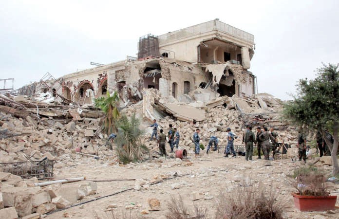عناصر من الجيش النظامي يتفقدون ما تبقى من فندق الكارتلون في حلب	اپ ﻿