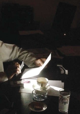 احد الموظفين يستعين بهاتفه النقال لتوقيع معاملة 