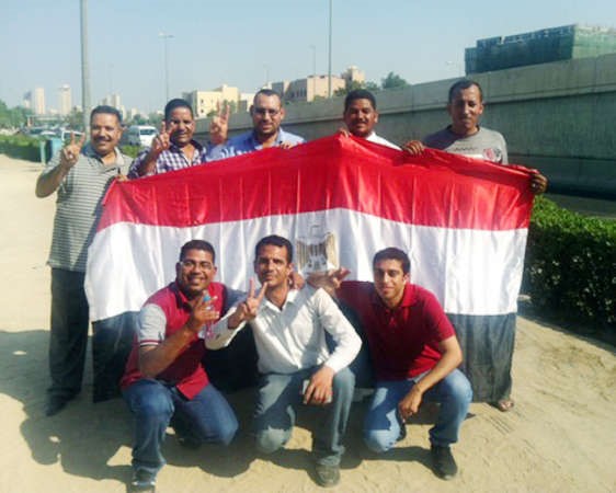 مصريون يرفعون علم بلدهم عقب تصويتهمبسفارة بلدهم امس الاول 