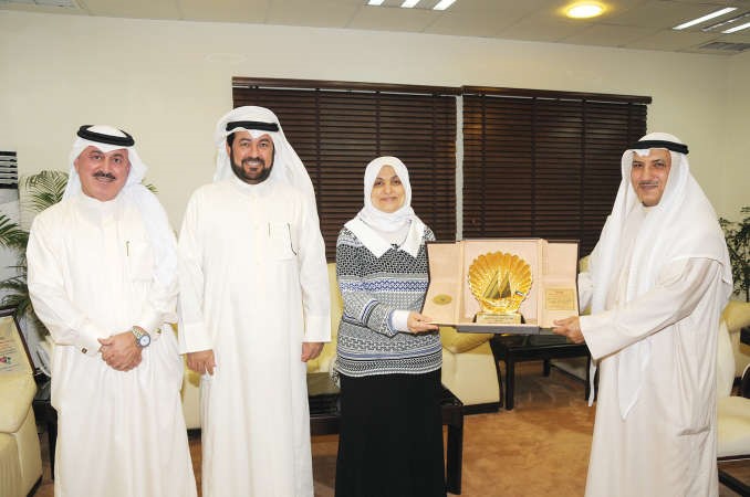 علي حسن يقدم درعا تكريمية الى الوزيرة هند الصبيح ويبدو بدر الردعان 