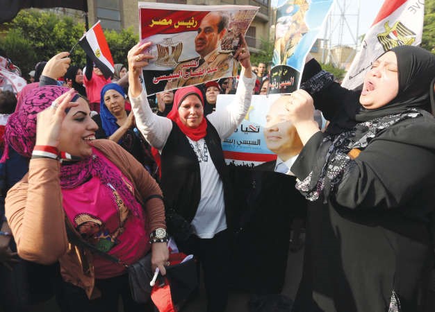 نسوة مصريات يزغردن ويرقصن امام احدى اللجان الانتخابية في القاهرة امس	رويترز ﻿
