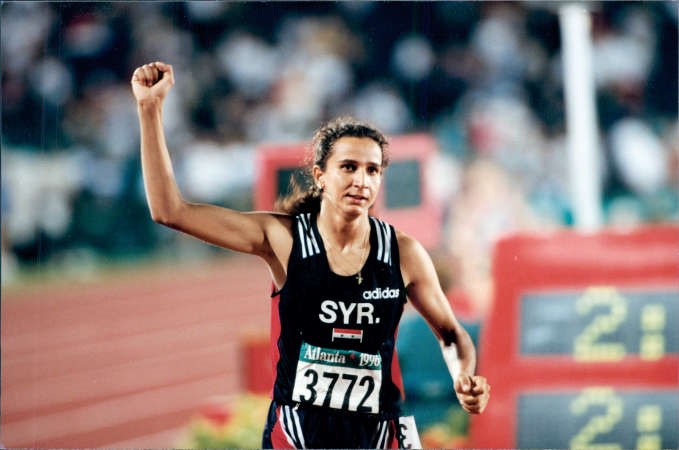 غادة شعاع ترفع يدها بعد احرازها ذهبية اولمبياد اتلانتا﻿