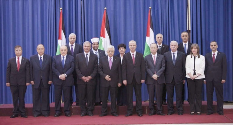  حكومة الوفاق الوطني الفلسطينية في صورة جماعية مع الرئيس عباس بعد ادائها القسم في رام الله امس 	اپ ﻿