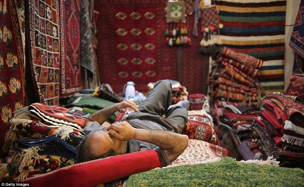 بائع سجاد في بزار الوكيل بمدينة شيراز، خلال وقت راحته