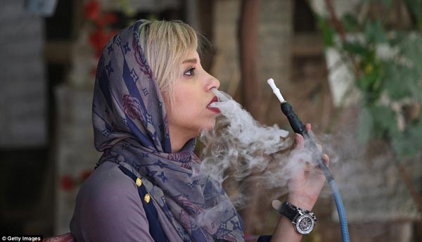 سيدة تدخن الشيشة خلال حضورها ورشة عمل عن الشعر والخط في شيراز، قلب الثقافة الفارسية على مدار 2000 عام