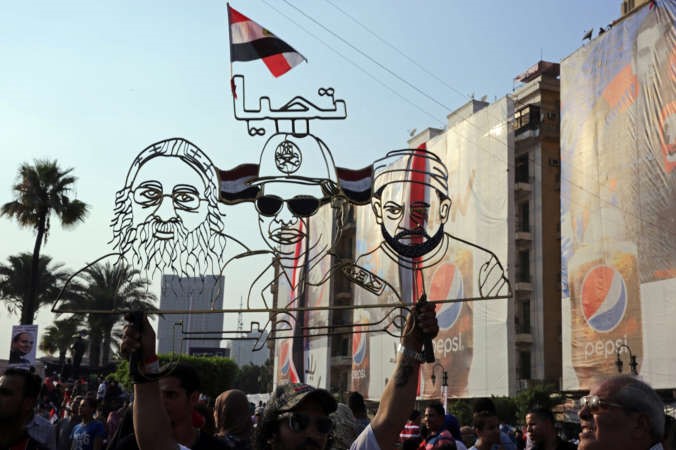 مجسمات رمزية للرئيس عبدالفتاح السيسي وشيخ الازهر د احمد الطيب والبابا تواضروس الثانيتبدو اثناء الاحتفالاتبالتنصيب الرئاسي في ميدان التحرير امس الاول اب 
