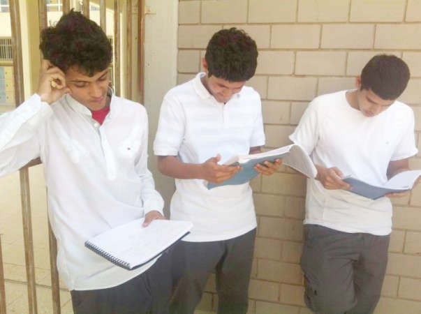 عدد من الطلبة يراجعون دروسهم قبل دخول الاختبار 
