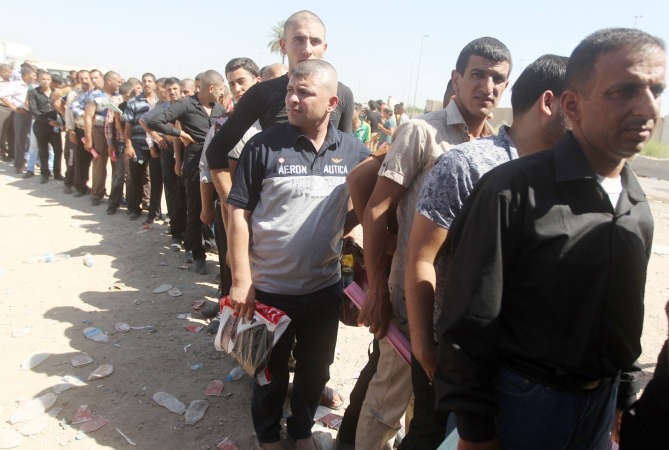 عراقيون يصطفون امام احد مراكز التطوع للقتال الى جانب الجيش العراقي في مواجهة المسلحين في بغداد امس	افب﻿