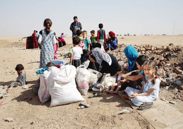 عائلات عراقية فرت من الموصل ليلة امس الاول تنتظر عند احدى نقاط التفتيش الكردية قرب اربيلاپ